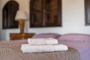 two towels sitting on top of a bed at Casa luxo, com 9 quartos vista mar Ubatuba in Ubatuba