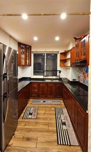 H1 Passion في مدينة هوشي منه: مطبخ مع دواليب خشبية وثلاجة حديد قابلة للصدأ