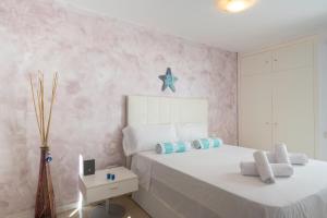 1 dormitorio con 2 camas y una estrella de mar en la pared en Pink Waves House en El Médano