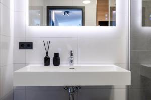 ein Badezimmer mit einem weißen Waschbecken und einem Spiegel in der Unterkunft Weitblick Winterberg in Winterberg