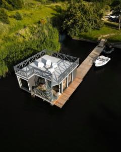 ein Haus auf einer Anlegestelle im Wasser in der Unterkunft Palikt niedrēs in Salacgrīva