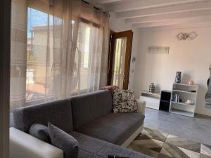 a living room with a couch and a large window at LA SCALINATA in Portoferraio