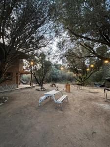una mesa de picnic y un banco en un parque en Casa corazon en San Marcos Sierras