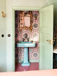 a bathroom with a sink and a mirror on a wall at Private and chique Salon de Franz - with large terrace in Amsterdam