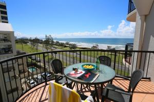 a table with a bowl of fruit on a balcony with the beach at Ocean Boulevard in Alexandra Headland