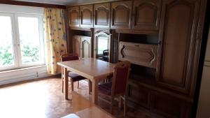 eine Küche mit einem Holztisch und Stühlen sowie einem Fenster in der Unterkunft Naturfreunde Alpenvorland in Kilb