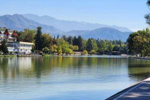 a lake with a house and mountains in the background at CERCA DE TODO amplio in Mendoza