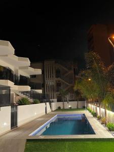 una piscina frente a un edificio por la noche en Elisa Apartment, en San Javier