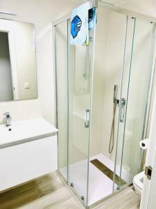 y baño con ducha acristalada y lavamanos. en Elisa Apartment, en San Javier
