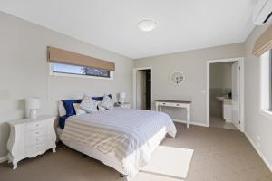 a white bedroom with a bed and a window at Central Townhouse For Six by Ready Set Stay in Cowes +6 photos