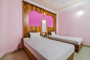 Habitación con 2 camas y espejo. en OYO Hotel C K International, en Bodh Gaya