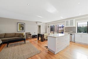 a kitchen and living room with a couch and a table at Central Townhouse For Six by Ready Set Stay in Cowes