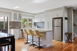 a kitchen with white cabinets and a refrigerator at Central Townhouse For Six by Ready Set Stay in Cowes