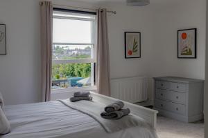 a bedroom with a bed with towels on it at Fabulous, vibrant, town house, central Bath Road in Cheltenham