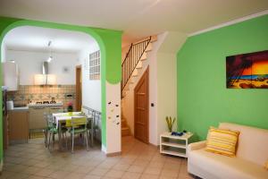 cocina y sala de estar con paredes verdes en Casa Tonia, en Praiano