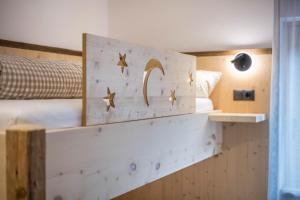 1 dormitorio con 1 cama y una pared de madera con estrellas en Forchnerhof Apt 1, en Terento