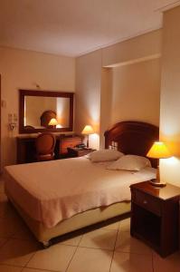 ein Schlafzimmer mit einem großen Bett und einem Spiegel in der Unterkunft Europa Beach Hotel in Galaxidi