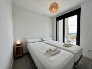 a white bedroom with a large bed and a window at Beautiful duplex modern apartment in Calpe - Inmodream Calpe in Ifach +26 photos