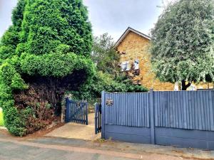 uma cerca azul em frente a uma casa em Potter's Escape-walking distance from The Studios! em Abbots Langley