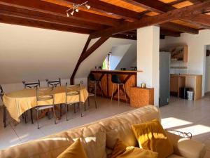 a living room with a couch and a table and chairs at Appartement Stotzheim La Romaine in Stotzheim