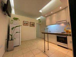 a kitchen with a white refrigerator and a counter top at La Escalerita- Estadio Kempes in Cordoba