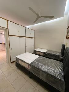 2 łóżka w pokoju z wentylatorem sufitowym w obiekcie La Escalerita- Estadio Kempes w Córdobie