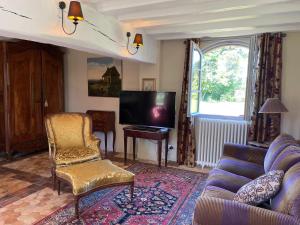 een woonkamer met een bank en een tv bij maison de charme à 1h 30 de Paris in Saint-Éman