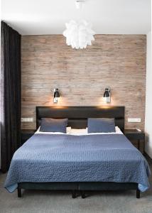 Hotel Grodzka 20 في لوبلين: غرفة نوم مع سرير مع لحاف أزرق