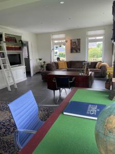 uma sala de estar com um sofá e uma mesa em Klein Nienoord Midwolde em Midwolde