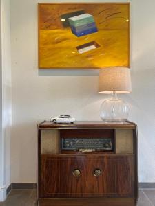 a table with a lamp and a painting on the wall at Klein Nienoord Midwolde in Midwolde