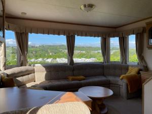 ein Wohnzimmer mit einem Sofa und einem Tisch in der Unterkunft Holiday Home by the sea in Aberystwyth