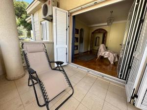 a rocking chair on the porch of a house at Apartments Villa Pržno in Sveti Stefan