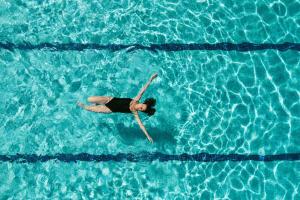 una mujer nadando en una piscina de agua en Hotel Terradets, en Cellers