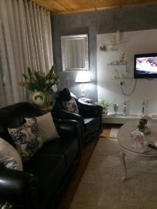 ein Wohnzimmer mit einem Sofa, einem Tisch und einem TV in der Unterkunft Sisi casa vacanze in Shkodra