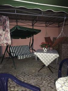 eine Terrasse mit einem Tisch und Stühlen unter einem Zelt in der Unterkunft Sisi casa vacanze in Shkodra