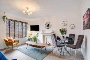 a living room with a table and chairs and a fireplace at Bourne Court Attractive 1 bedroom Apt by MDPS in Ruislip