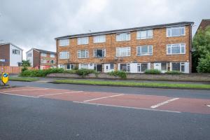 um parque de estacionamento vazio em frente a um edifício de tijolos em Bourne Court Attractive 1 bedroom Apt by MDPS em Ruislip