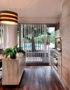 een keuken met een grote glazen schuifdeur naar een zwembad bij The Bamboo villa in Casale la Cogna