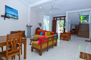 een woonkamer met een bank en een tafel en stoelen bij Thinaya lake resort in Anuradhapura