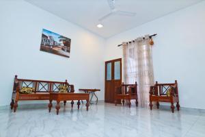 ein Zimmer mit 3 Stühlen und einer Wand mit einem Bild in der Unterkunft Thinaya lake resort in Anuradhapura