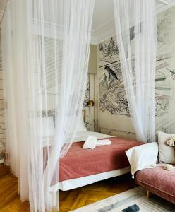 a bedroom with a bed with curtains and a couch at Ultracentral Lux Boutique 1BR Ap Near Subway in Bucharest