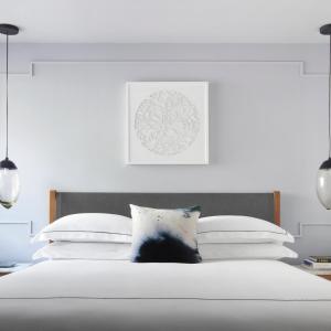 1 dormitorio con cama blanca y almohadas blancas en Kimpton Virgilio en Ciudad de México
