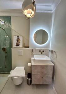 a bathroom with a sink and a toilet and a mirror at Ultracentral Lux Boutique 1BR Ap Near Subway in Bucharest