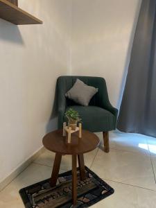 a living room with a green chair and a table at Loft atardecer in Uruapan del Progreso
