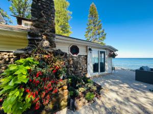 una casa con flores y una pared de piedra en Inn the Cedars, en Meaford