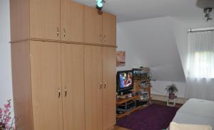 a living room with wooden cabinets and a tv at Charmantes Appartement - München in Munich