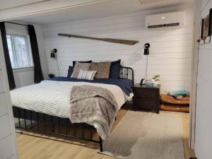 1 dormitorio con 1 cama en una habitación con paredes blancas en The Old Kettle Cabin with Hot Tub, en Mill Village