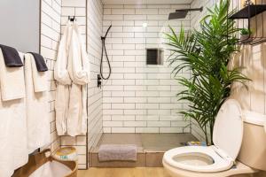 a bathroom with a toilet and a plant at The Old Kettle Cabin with Hot Tub in Mill Village