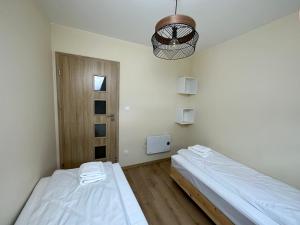 a room with two beds and a light fixture at Wyspa Wisła Przyjazna Przystań Stężyca in Stężyca