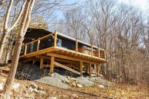 a wooden house in the middle of the woods at The Old Kettle Cabin with Hot Tub in Mill Village